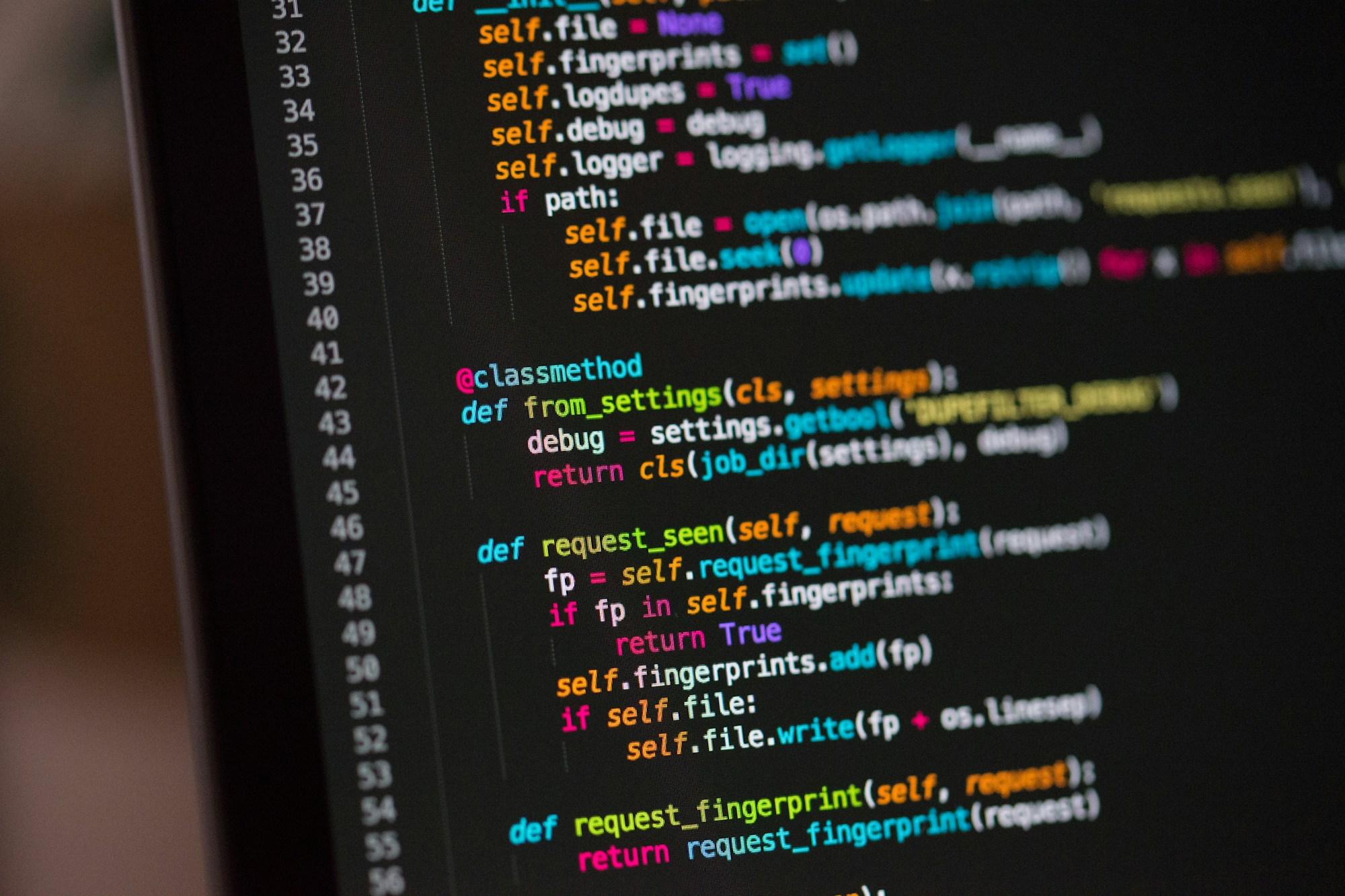 Code on a laptop screen in a dark room